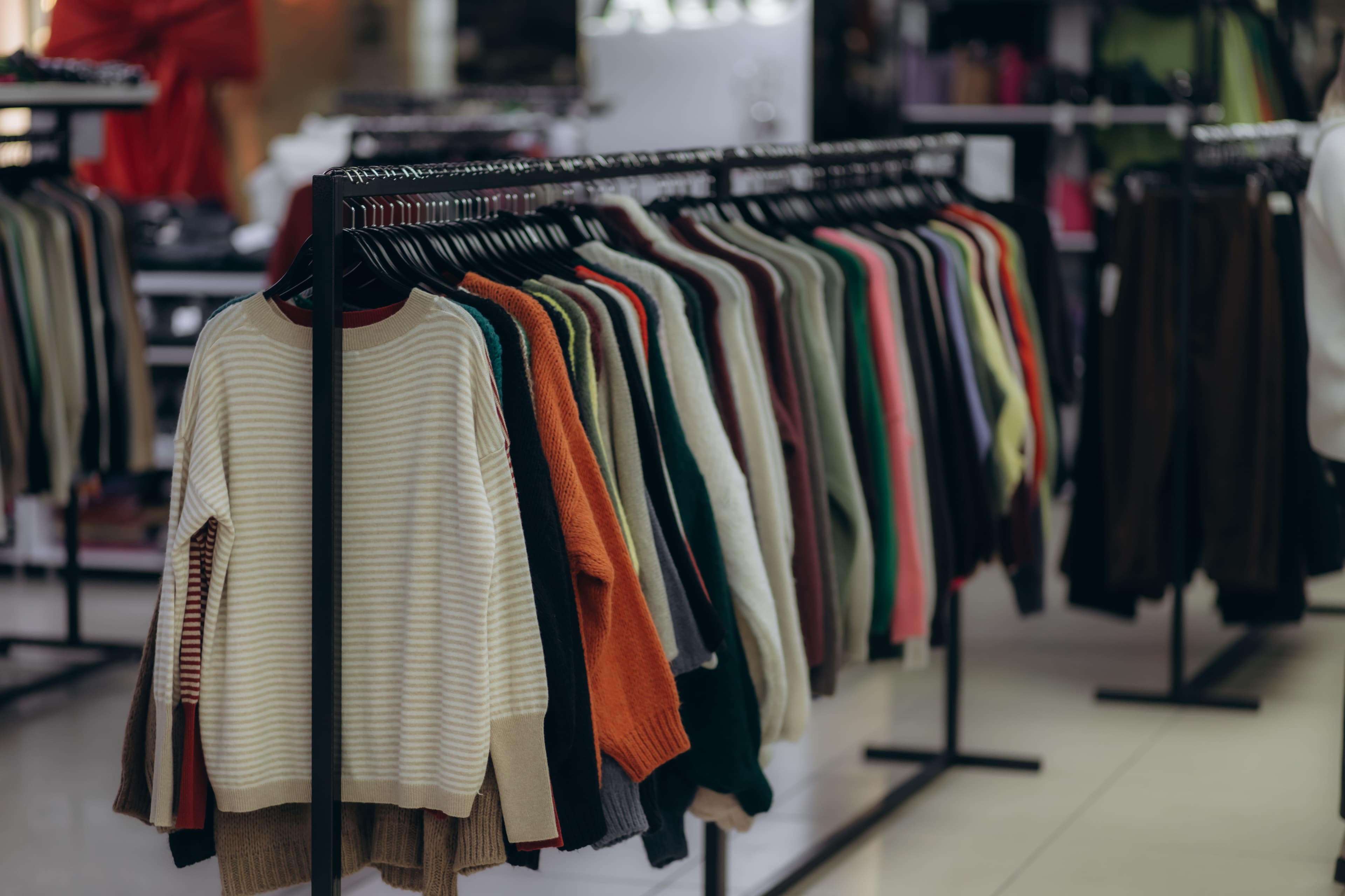 Stylist helping a customer choose a garment in a fashion store