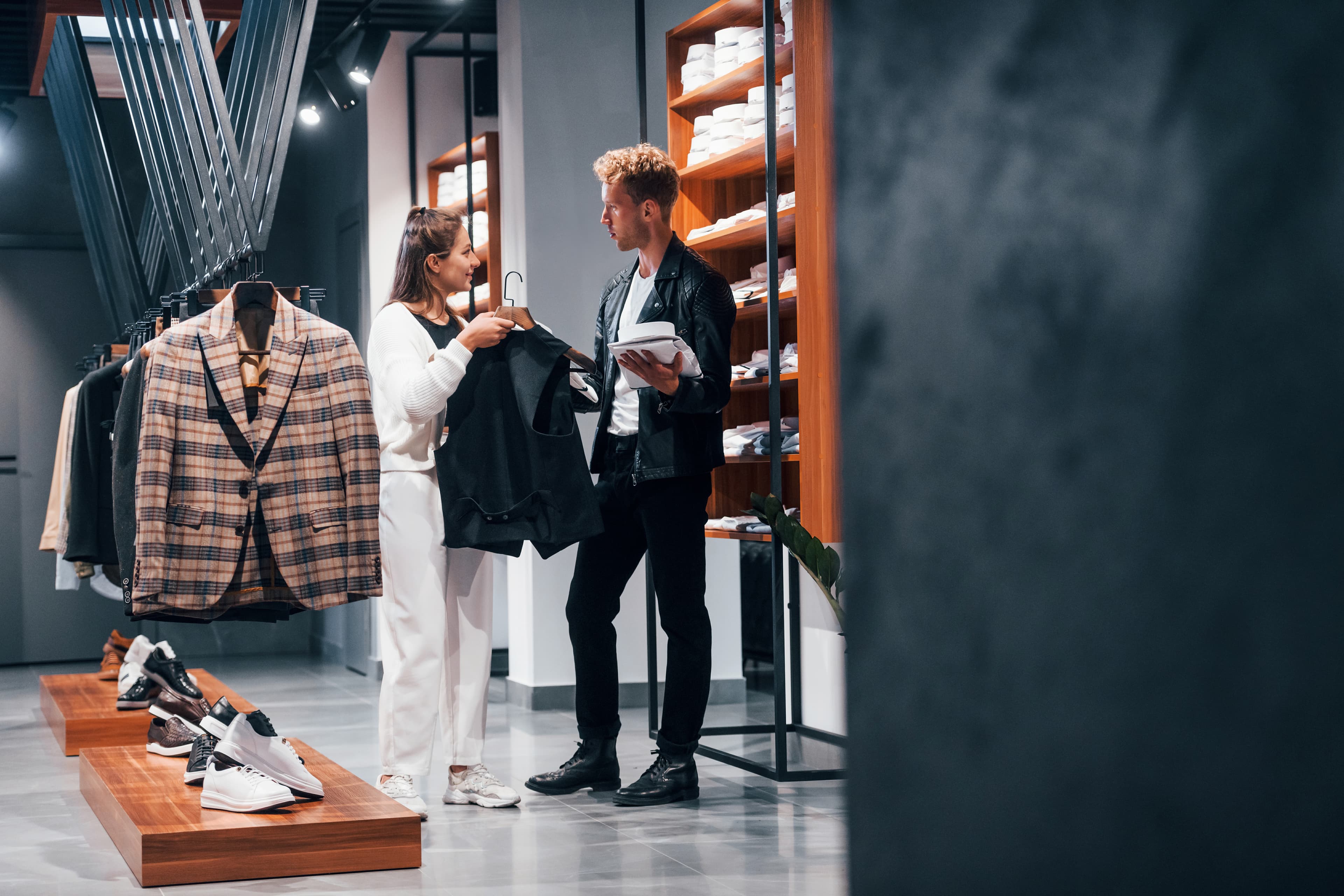 Fashion retail store with a stylist helping a customer choose a garment